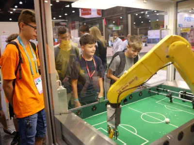 Young School pupils watching Robots play football