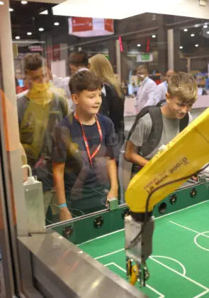 Young School pupils watching Robots play football